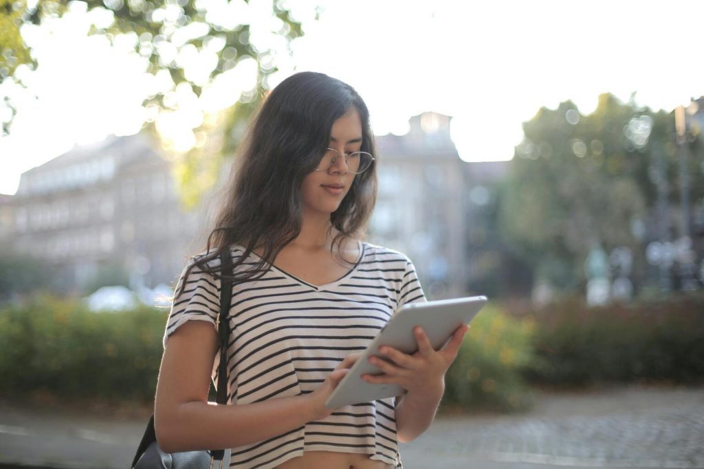 Calm pensive female freelancer using digital tablet on street.

More info